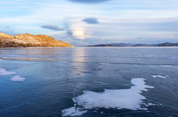 Unusual scenic landscape of frozen Baikal Lake in December cold  day. View on clear ice fields of Kurkut bay of Small Sea at sunset. Nature winter park