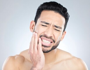 Obraz premium Close-up of a man in pain, holding his cheek. He's visibly distressed, with a pained expression and clenched teeth