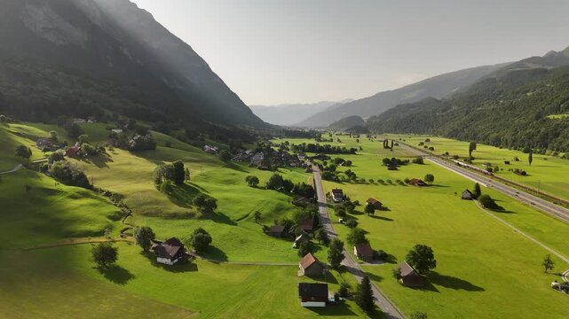 Aerial Drone View of Green Valley with Villages, Roads, and Mountains in the Swiss Alps near Flums and Walenstadt, St. Gallen, Switzerland