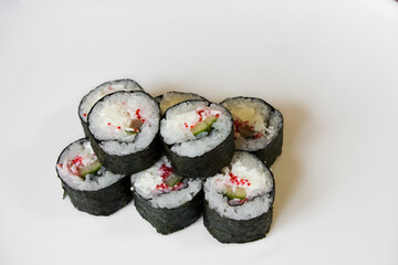 Stack of sushi rolls with white soft cheese and cucumber on a white background