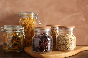 Glass jars with different products on wooden table