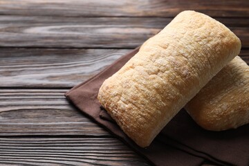 Freshly baked ciabattas on wooden table, closeup. Space for text