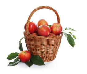 Fresh apples in wicker basket and green leaves isolated on white