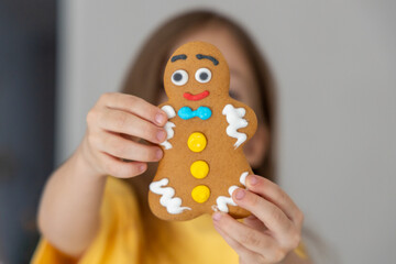 Gingerbread man, child holding gingerbread man cookie in hands