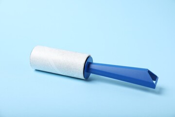 One lint roller on light blue background, closeup