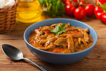 Boeuf, Stroganow, Strogonow. Classic, Russian beef stew.  Served in a blue bowl. Front view. Natural background.