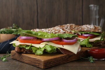 Tasty ciabatta sandwich with cheese and vegetables on wooden table, closeup