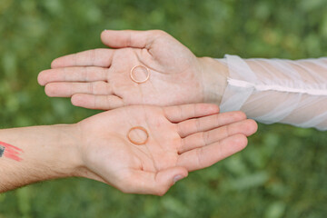 A man removes a gold wedding ring from his left hand ring finger