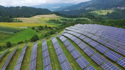 Industrial drone flying over solar panel farm on green hillside, renewable energy and modern technology in rural mountain landscape, Roana, Italy. Aerial - Powered by Adobe
