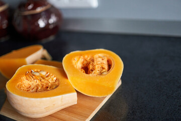 Pumpkin on a cutting board on a kitchen countertop.