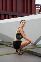 Fashion shoot with a professional model, a girl on the roof of a building in stylish clothes.