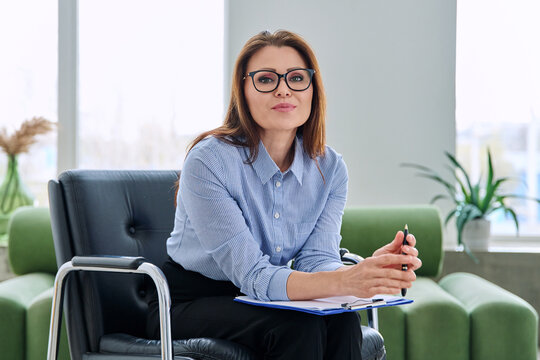 Portrait of professional psychologist therapist woman with clipboard in office