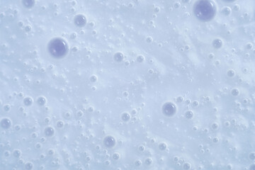 Close-up of light blue surface with scattered translucent bubbles of varying sizes. Gentle, pastel look with a clean, modern feel. Soft lighting and minimal texture.