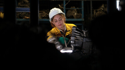 Female engineers wearing safety helmet gear inspecting car parts inventory
