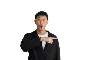 Shocked face young Asian man in black coat pointing thumbs up isolated on a white background. The person's index finger pointing to a blank space for text