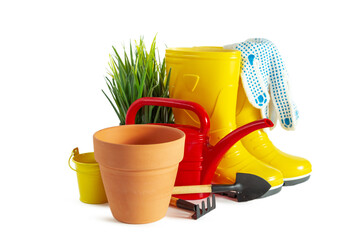 Yellow rubber boots, watering can and garden tools. Isolated on white background.