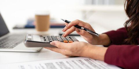 Finance, budgeting and tax calculation. Close up woman hand using calculator to calculate  finance, accounting.