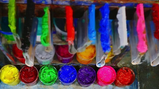 Colorful Ink for Screen Printing Factories
Inside a busy T-shirt factory plastisol inks in multiple tones bright and dark are neatly arranged for industrial use. Workers use handmade tools, handles