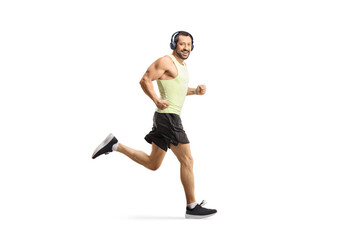 Full length shot of a man jogging with headphones and looking at camera