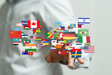 A person's hand interacts with multiple country flags, symbolizing globalization, international...