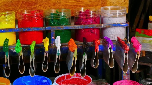 Colorful Ink for Screen Printing Factories
Inside a busy Tee shirt factory plastisol inks in multiple tones bright and dark are neatly arranged for industrial use. Workers use handmade tools handles