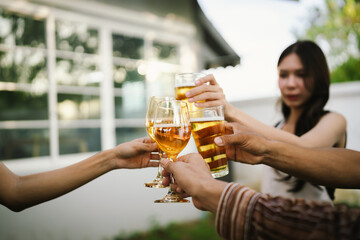 Happy young friends celebrate together at a stylish restaurant, enjoying wine, laughter, and friendship during an elegant evening gathering.	