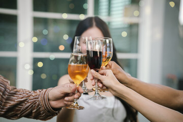 Happy young friends celebrate together at a stylish restaurant, enjoying wine, laughter, and friendship during an elegant evening gathering.	