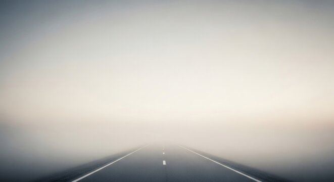 An empty asphalt highway disappearing into a mysterious and dense white fog, symbolizing an uncertain journey into the unknown