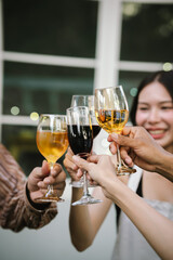 Happy young friends celebrate together at a stylish restaurant, enjoying wine, laughter, and friendship during an elegant evening gathering.	