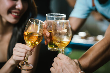 Happy young friends celebrate together at a stylish restaurant, enjoying wine, laughter, and friendship during an elegant evening gathering.	