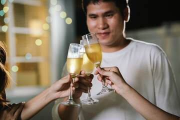 Happy young friends celebrate together at a stylish restaurant, enjoying wine, laughter, and friendship during an elegant evening gathering.	