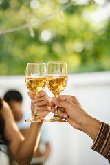 Happy young friends celebrate together at a stylish restaurant, enjoying wine, laughter, and friendship during an elegant evening gathering.	