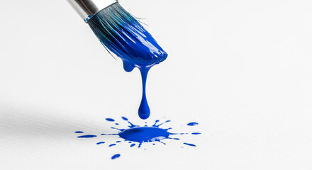 Closeup of a paintbrush dripping blue paint onto a white background, creating a splash of color, isolated on white background