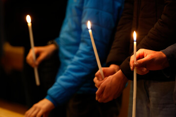 Holy week. Celebration of the Easter Vigil.  Christian assembly with a lit candle. Annecy. France.