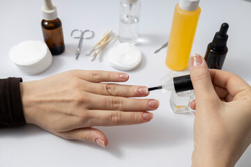 Woman with damaged nails using clinic healthcare nail polish, gel strengthener for repair and protect