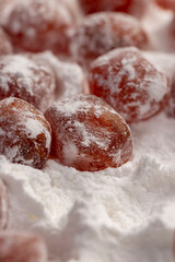 dry kumquat and powdered white sugar, sweet dried orange kumquat fruits in white powdered sugar