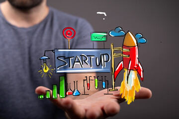 Hand holding a startup concept with rocket launch.  New business, innovation, growth.