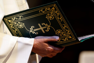 Catholic church. Priest holding a liturgical book. Sunday mass.  Sallanches. France.