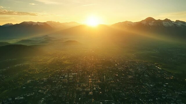 City receiving golden sun rays during sunrise in mountains