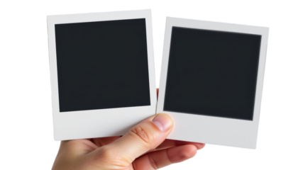 Hand Holding Two Blank Photos Indoor Setting Image Capture Minimalist Style Close-Up Perspective Personal Memories