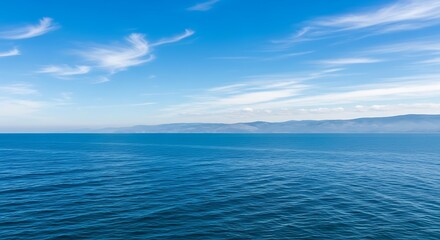 Fototapeta premium Vast blue ocean meets the horizon under a sky with wispy clouds