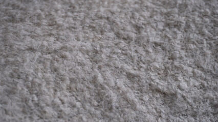 Soft wool fabric texture in neutral gray tone. Cozy and warm fabric texture ideal for use as background, interior design material, textile pattern, or mockup element.