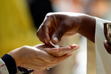 Catholic mass. Holy communion.  A priest holds a communion wafer, symbolizing the body of Christ.  La Roche sur Foron.  France.