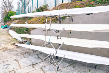 Rack holds several racing shells, known as fine boats. These long, narrow boats are designed for competitive rowing and are stored together when not in use