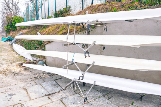 Rack holds several racing shells, known as fine boats. These long, narrow boats are designed for competitive rowing and are stored together when not in use - Powered by Adobe