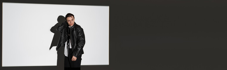 Stylish young man poses against a minimalist background showcasing youth culture and fashion trends