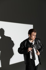 Stylish teenager showing confidence while posing in a modern studio setting with dramatic light