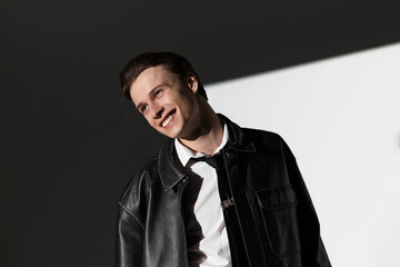 Fototapeta premium Stylish young man exudes confidence and charm in contemporary youth culture setting