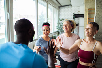 Senior women exercising with trainer
