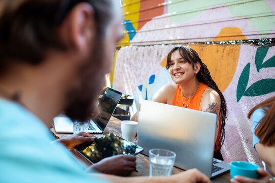 Group of friends using a laptop outdoors for work